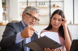 serious mature legal advisor reading analyzing explaining document female customer 1