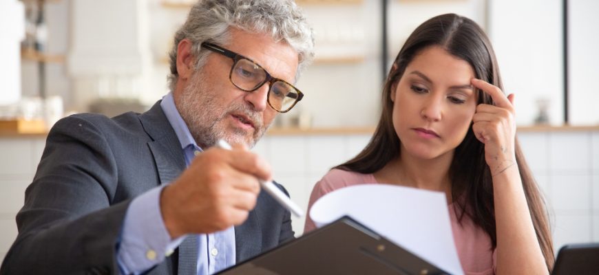 serious mature legal advisor reading analyzing explaining document female customer 1